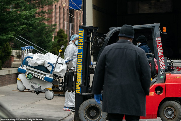 Hospital orderlies loading corpses onto truck in Brooklyn New York, March 2020.